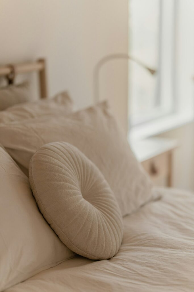 A bed with a white comforter and pillows