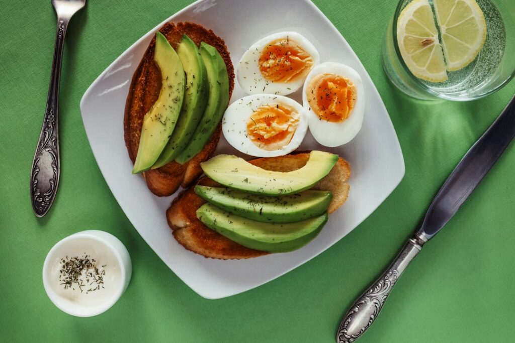 A white plate topped with eggs and avocado